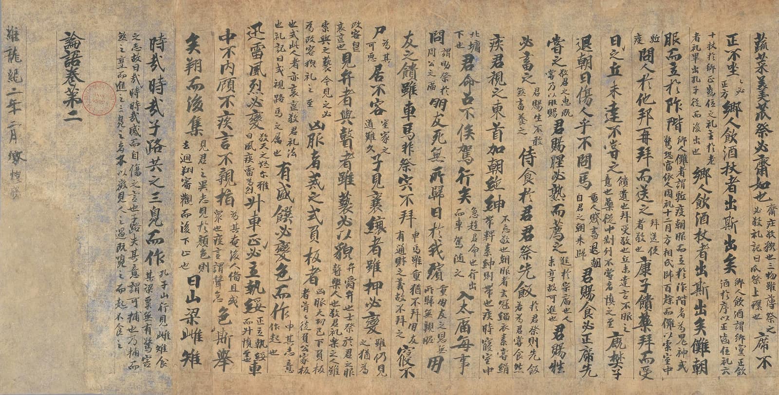 A length of yellowed paper scroll written in vertical columns of Chinese characters in black ink, large characters for the text and pairs of smaller columns for the commentary; at the right edge the chapter title and a date line, and a small red seal stamp near the top.